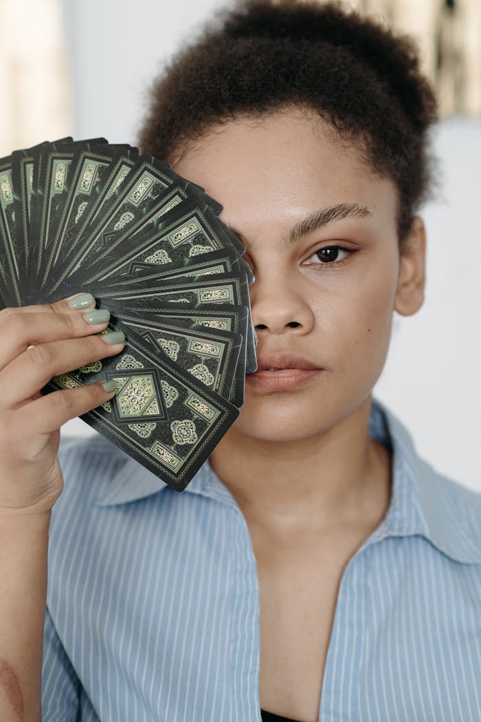 A young woman holding tarot cards, capturing a mystical and introspective moment.